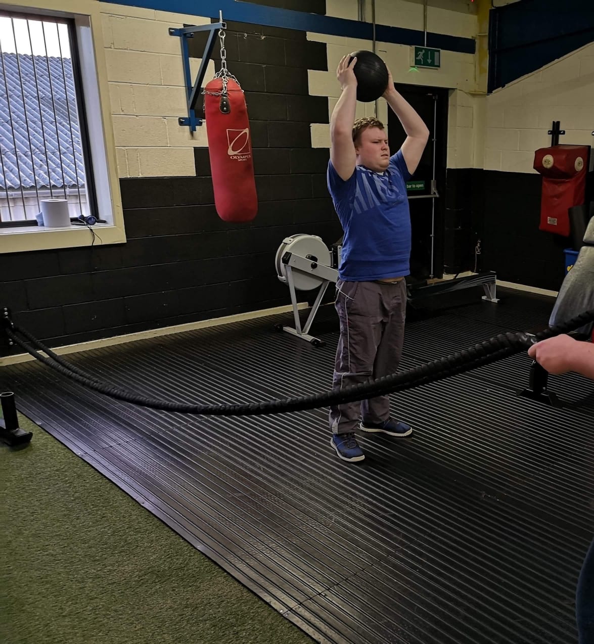 Young man lifting weights in a gym